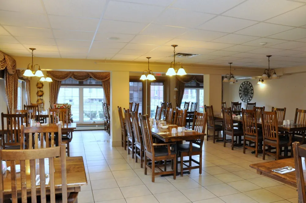 Parkview Retirement Home's main-floor dining room with wooden tables and brass chandeliers