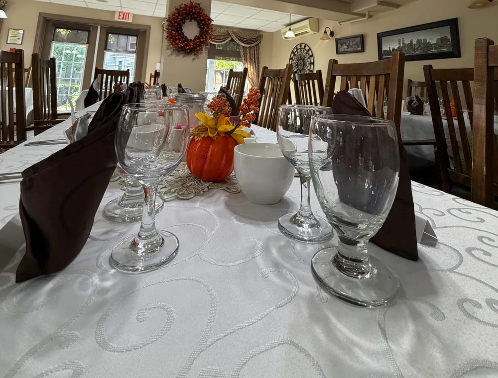 Glasses, folded napkins and a pumpkin centrepiece on a table set for Thanksgiving dinner